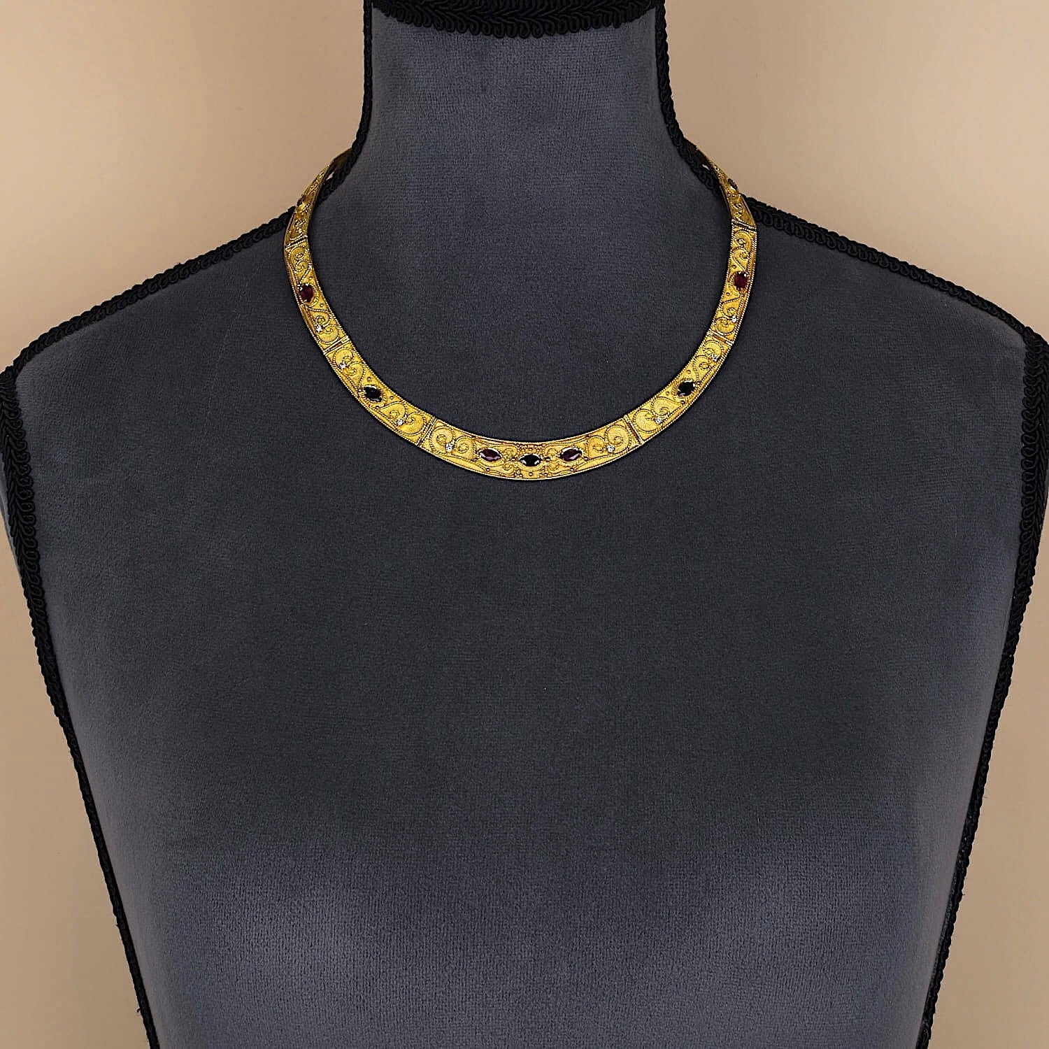 Heavy, luxurious necklace in 750 yellow gold with blue sapphires, rubies and Brilliants, on a dark bust
