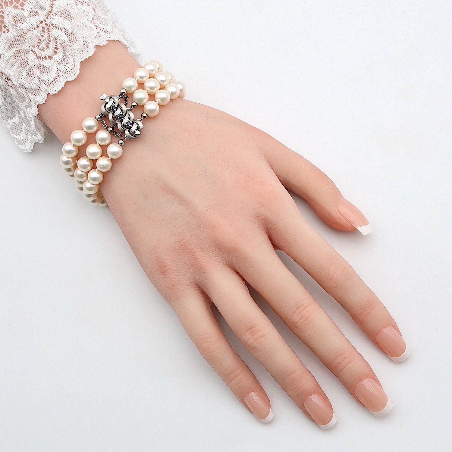 Bracelet with cultured pearls. The lock is crafted in 333 white gold with sapphires.