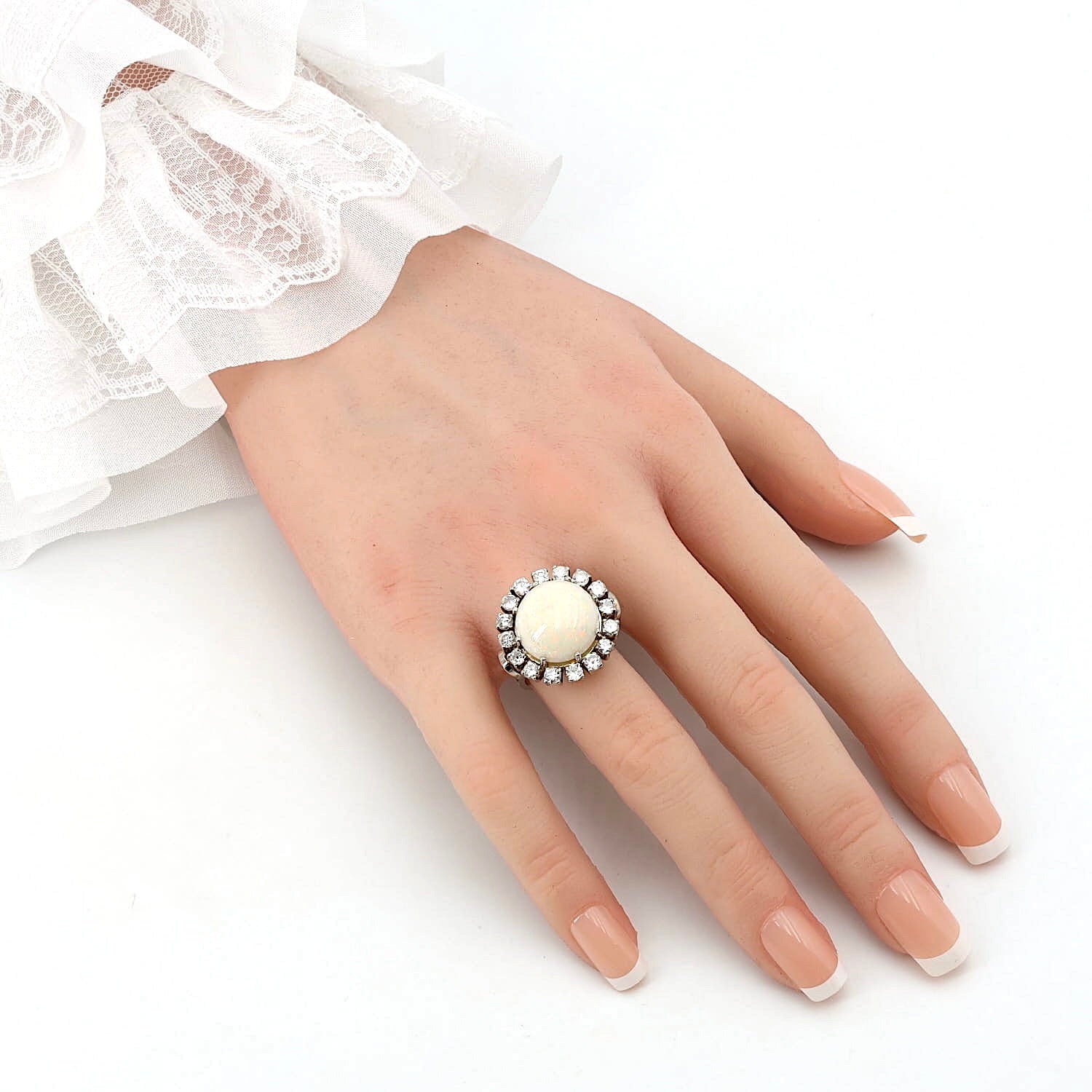 Cocktailring in 585er Weißgold mit einem großen Opal-Cabochon und ca. 1,28 ct Brillanten, an der Hand