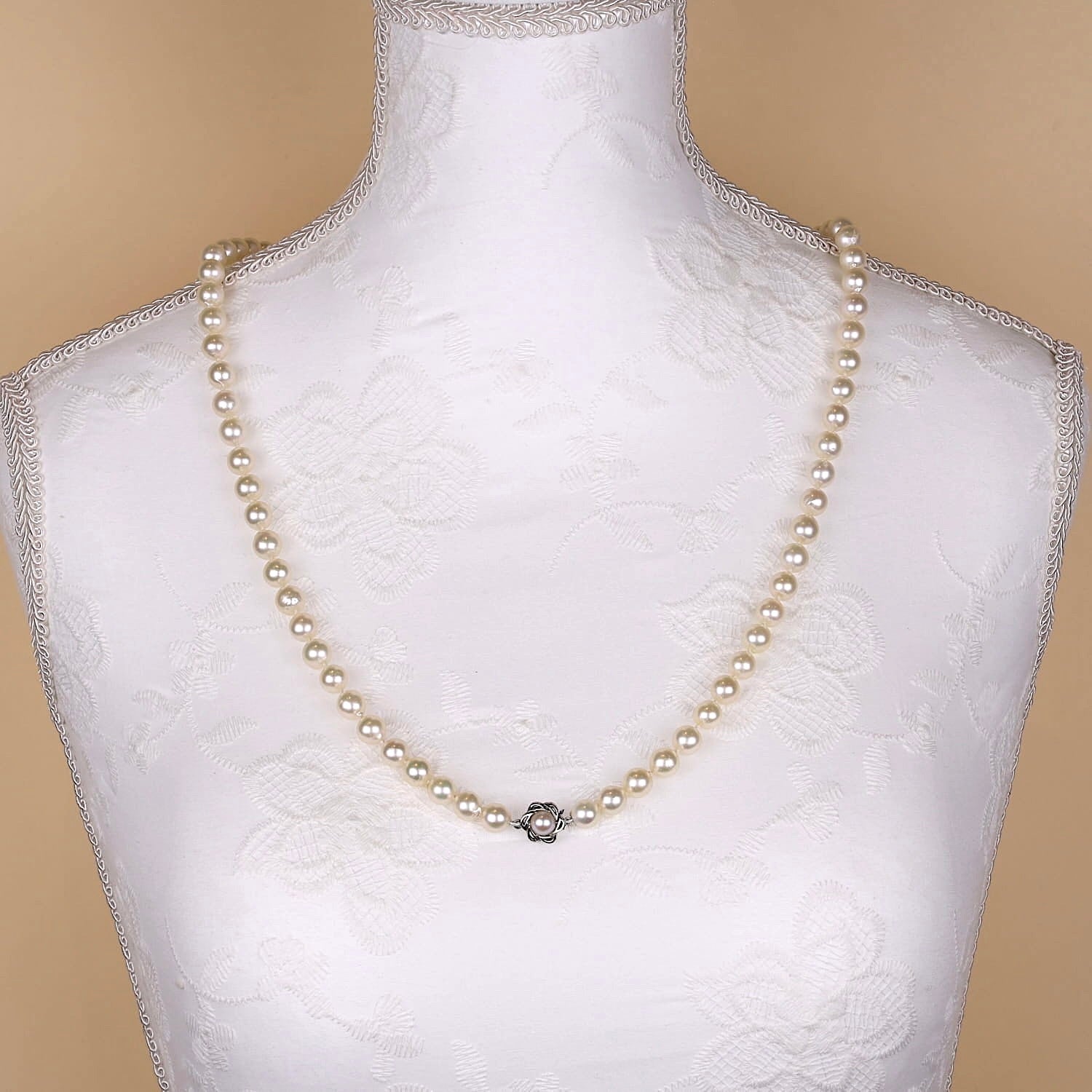 Lange Akoya-Zuchtperlenkette mit einem Schloß aus 585er Weißgold, Land an einer weißen Büste