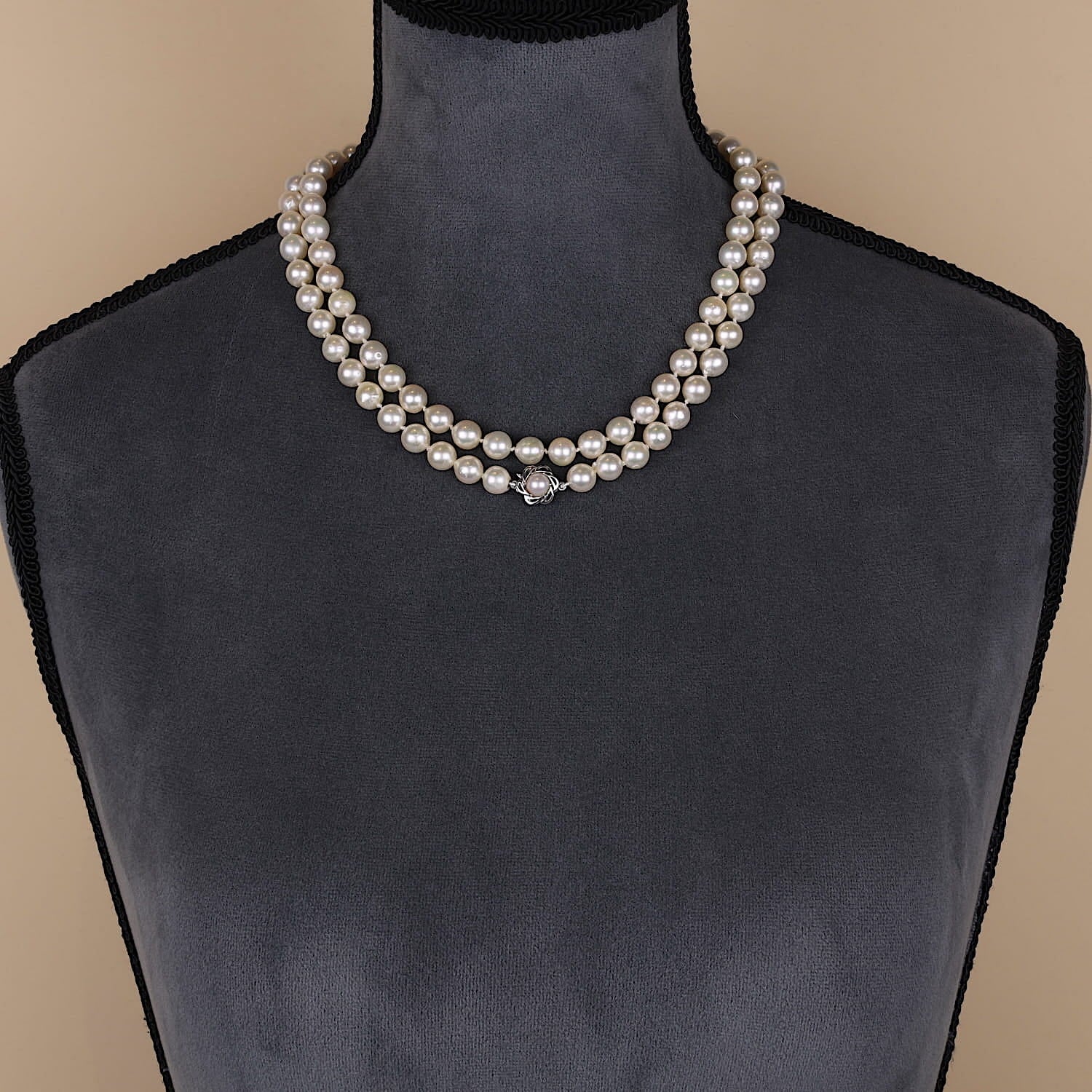 Lange Akoya-Zuchtperlenkette mit einem Schloß aus 585er Weißgold, doppelt gelegt an einer dunklen Büste