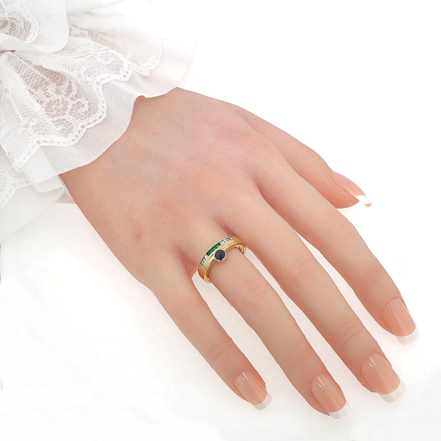 Buchwald ring in 750 yellow gold with diamonds, emeralds and a sapphire cabochon