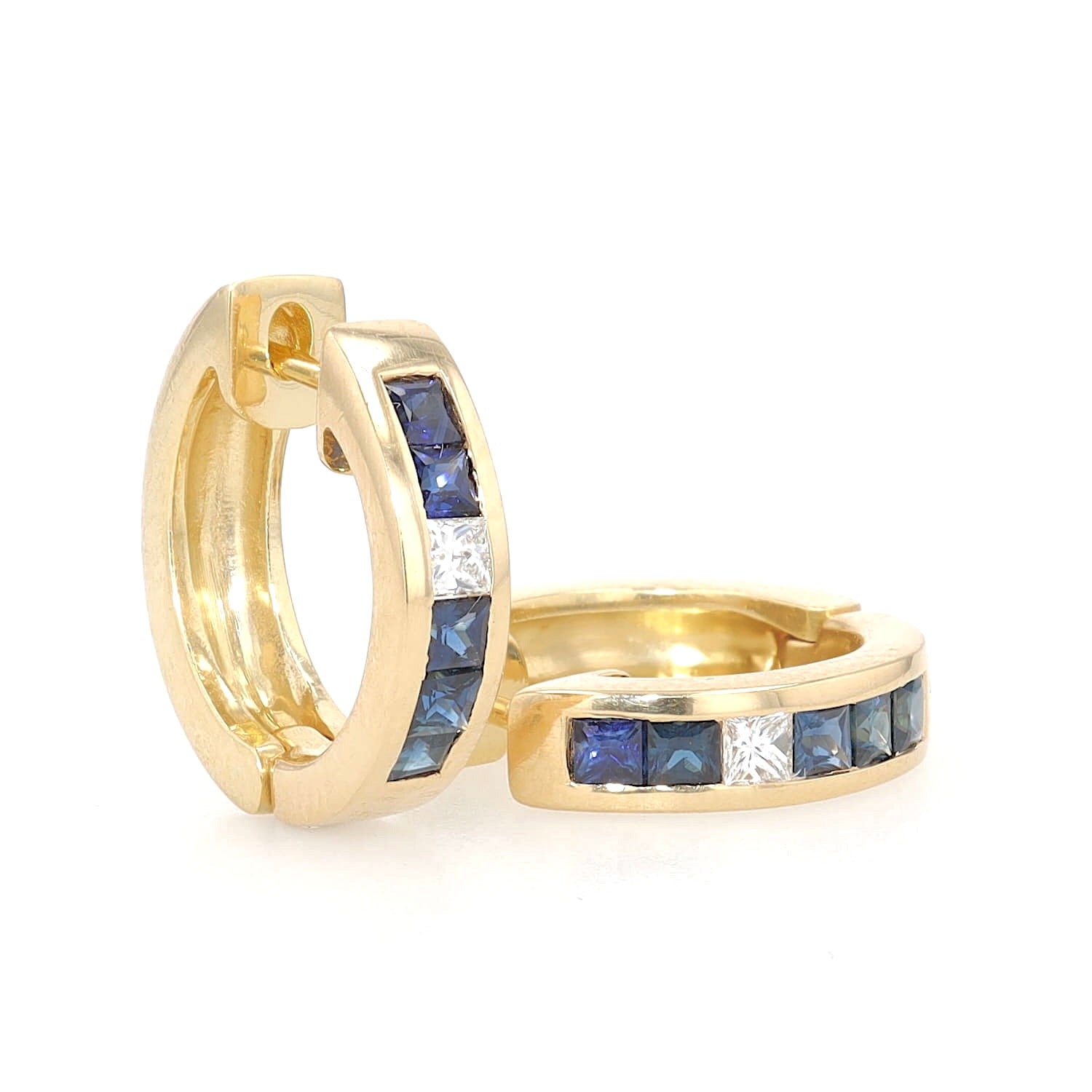 A pair of hoop earrings in 750 yellow gold with diamonds and sapphires, one standing, one lying, turned to the left