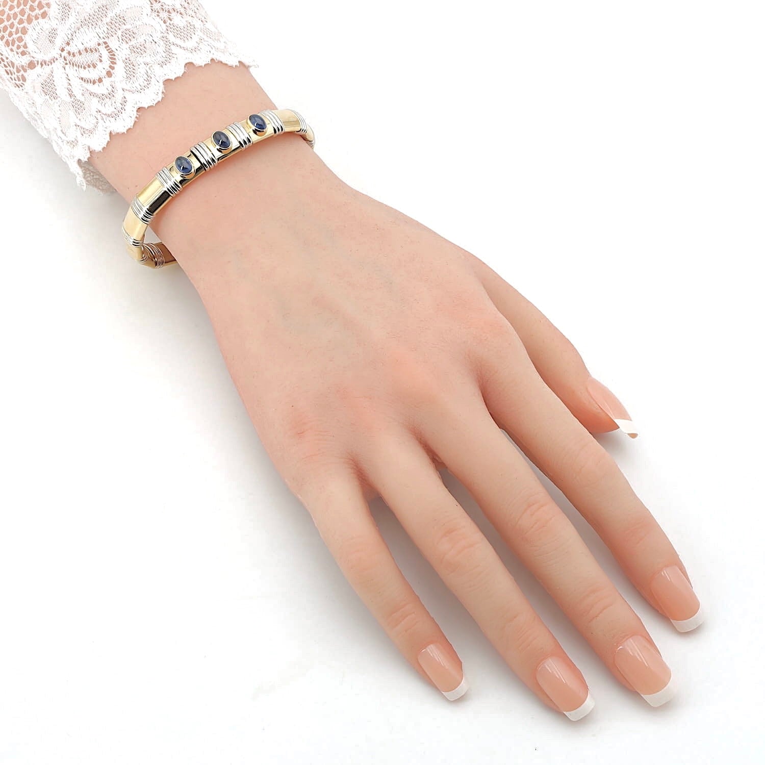 Bangle in 750 yellow and white gold with sapphire cabochons, on the arm