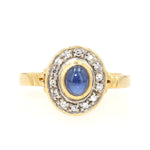Ring in 750er Gelbgold mit einem blauen Saphir-Cabochon und Diamanten, liegend frontal