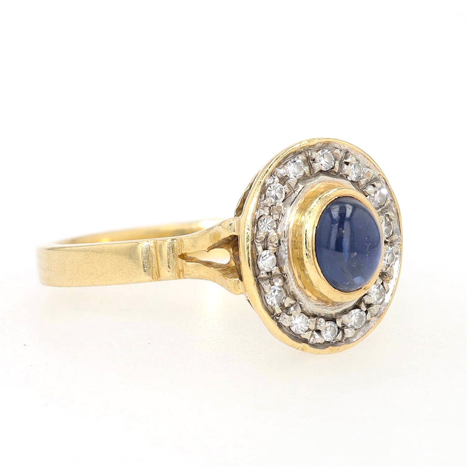 Ring in 750er Gelbgold mit einem blauen Saphir-Cabochon und Diamanten, liegend rechts gedreht