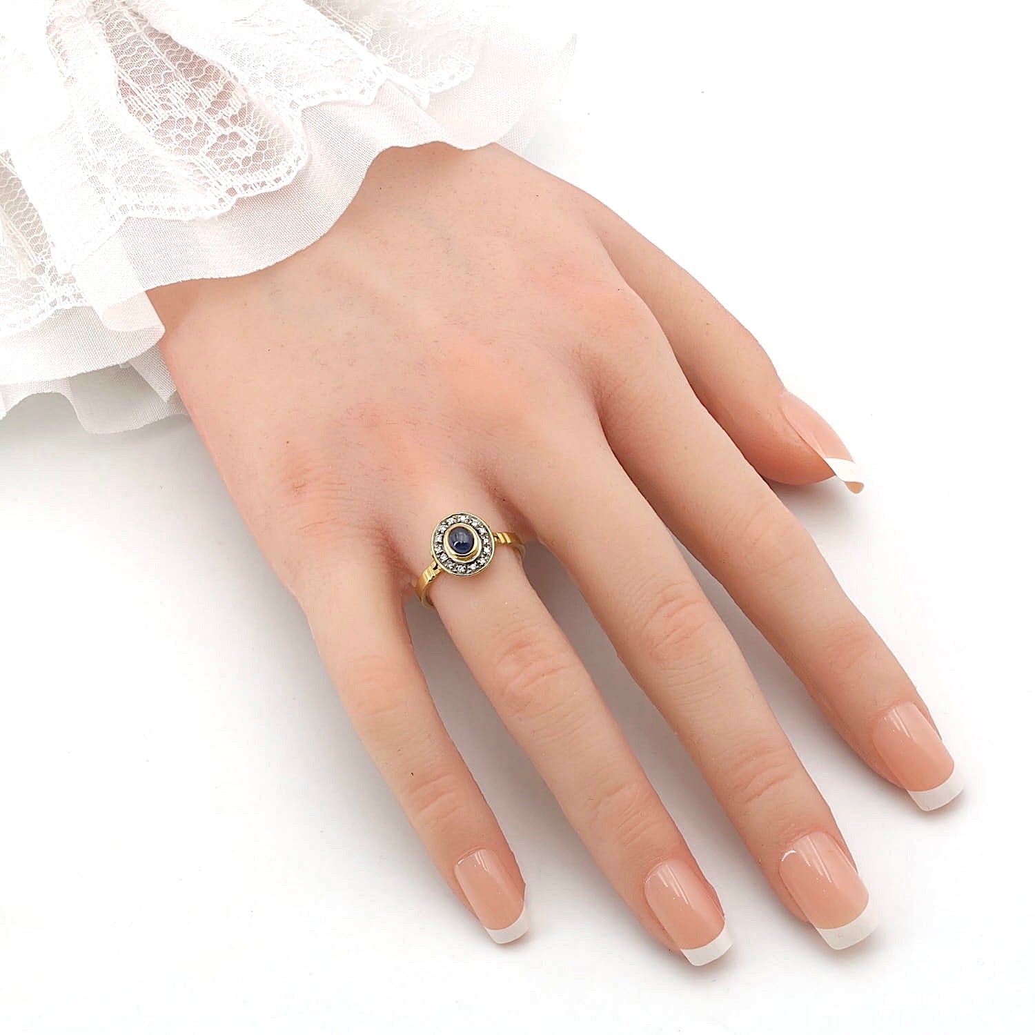 Ring in 750er Gelbgold mit einem blauen Saphir-Cabochon und Diamanten, an der Hand