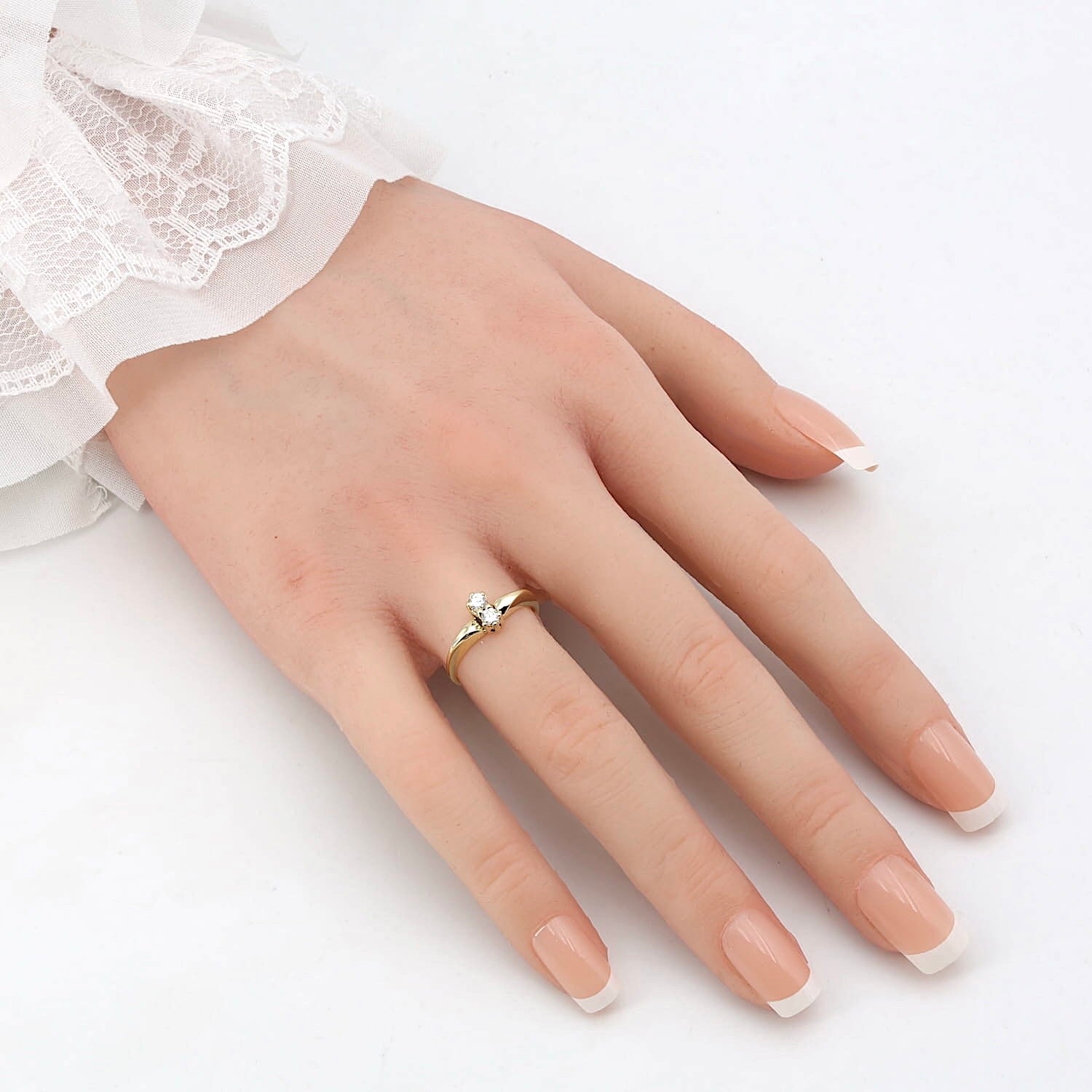 Ring in 585er Gelbgold mit zwei Brillanten, an einer künstlichen Hand