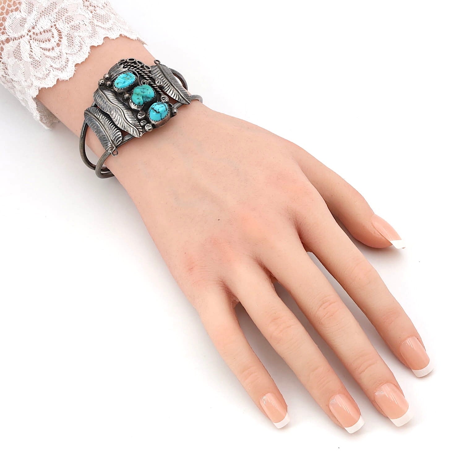 Armspange Indianerschmuck Navajo in 900er Silber mit Türkisen, am Arm einer künstlichen Hand