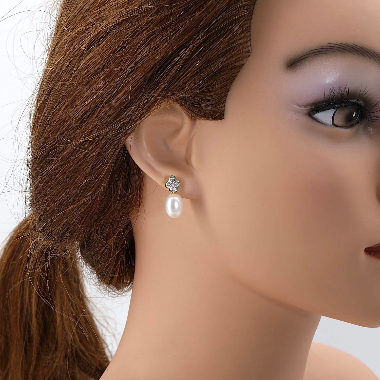 Ohrringe in 750er Gelbgold mit je einer Südsee-Zuchtperle und Brillanten, einzeln am Ohr einer Puppe