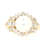 Ring in 750 yellow gold with a cultured pearl and diamonds, lying frontally