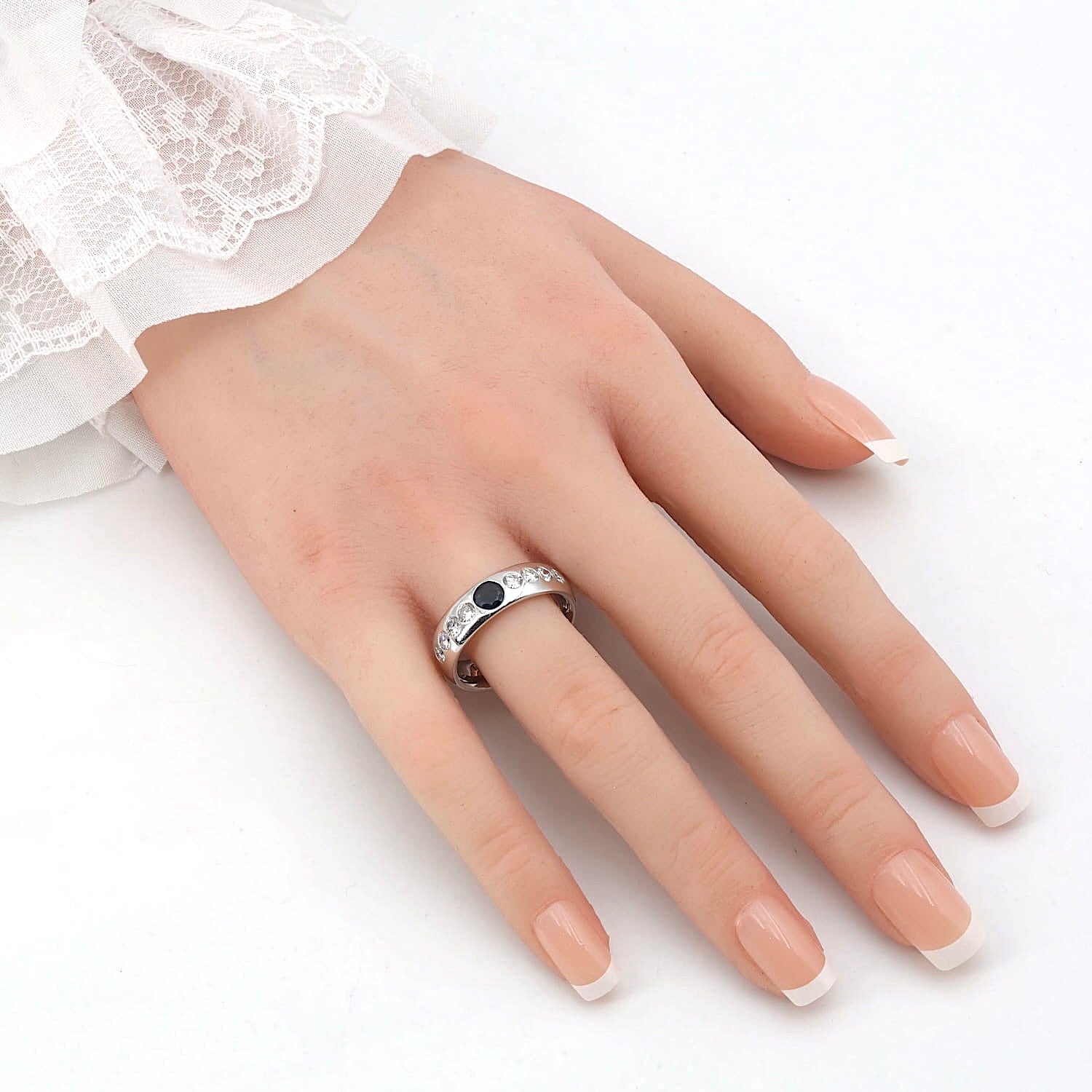 Ring in 585er Weißgold mit einem Saphir und Brillanten, an einer künstlichen Hand