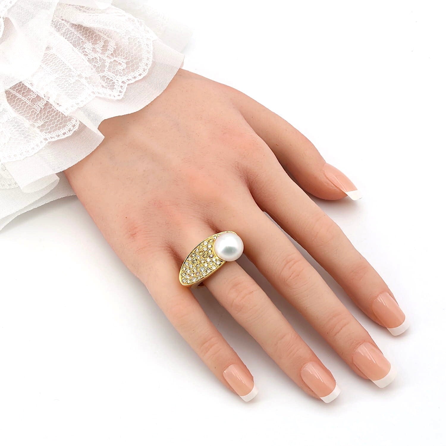 Ring von der Manufaktur Gellner in 750er Gelbgold mit einer großen Südsee-Zuchtperle und Brillanten, an einer künstlichen Hand