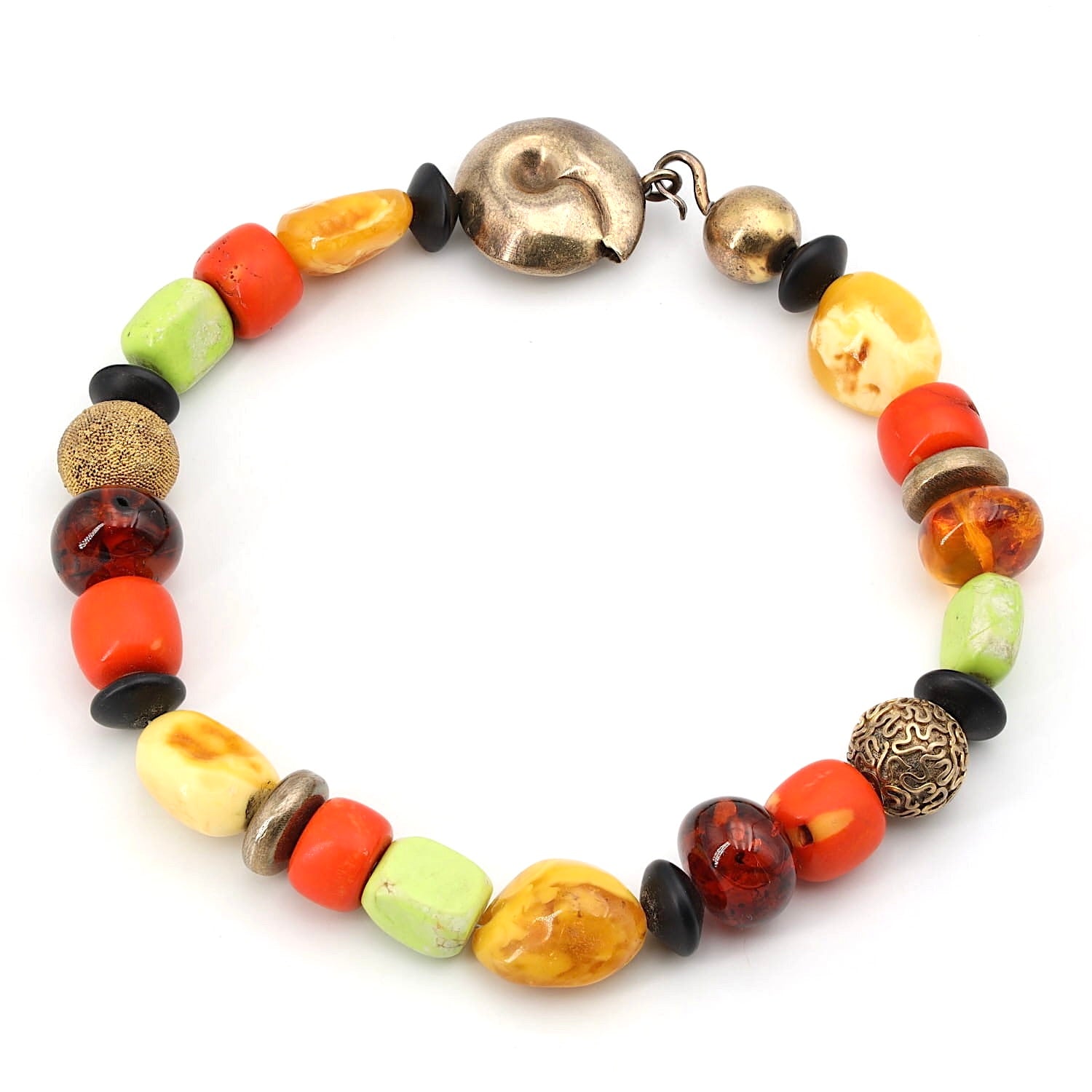 Designer necklace with amber, coral, magnesite and gold-plated silver elements, lying closed top view