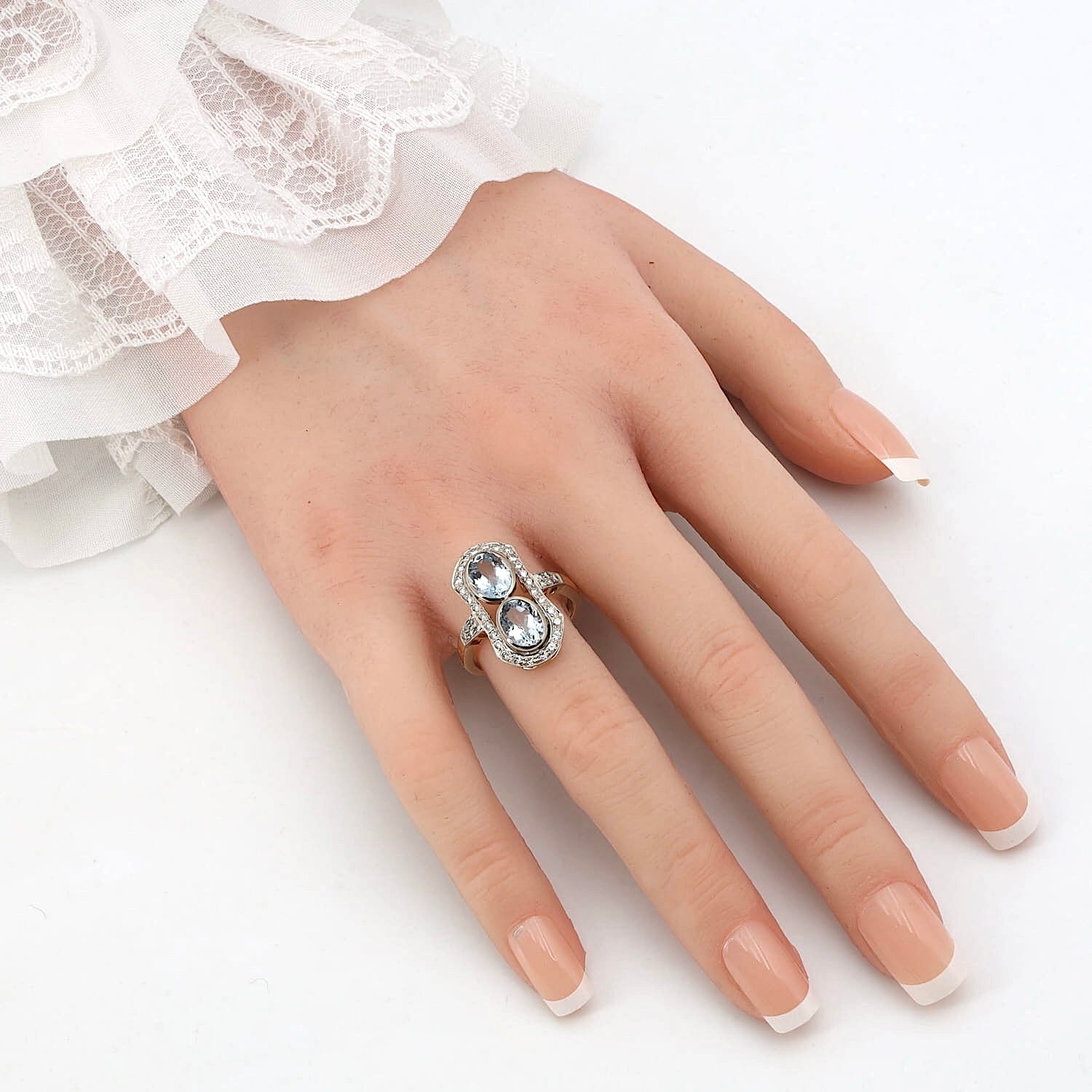Art Déco Ring in 750er Gold mit zwei Aquamarinen und Brillanten, an einer künstlichen Hand
