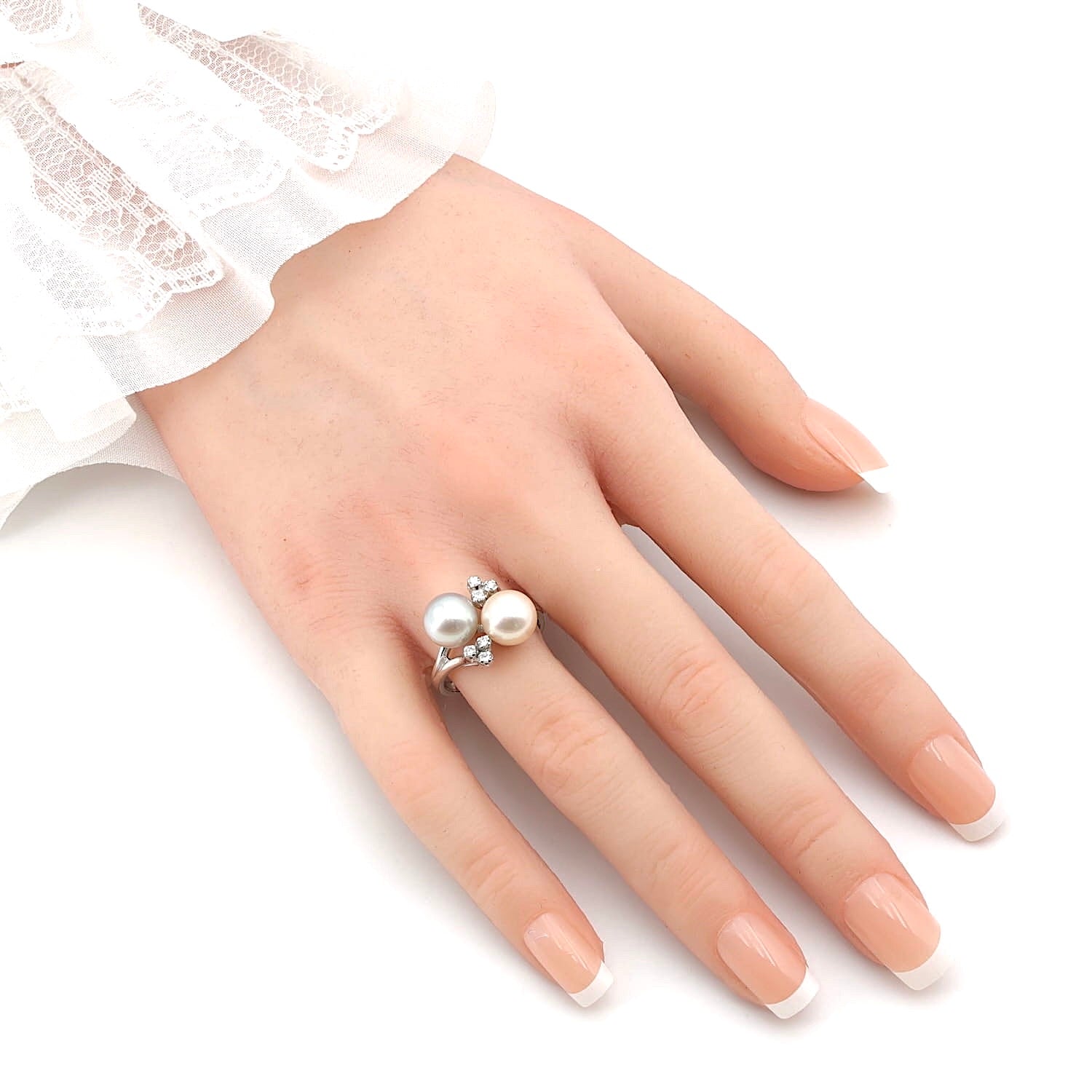 Ring in 750er Weißgold mit zwei Zuchtperlen und Diamanten, an einer künstlichen Hand
