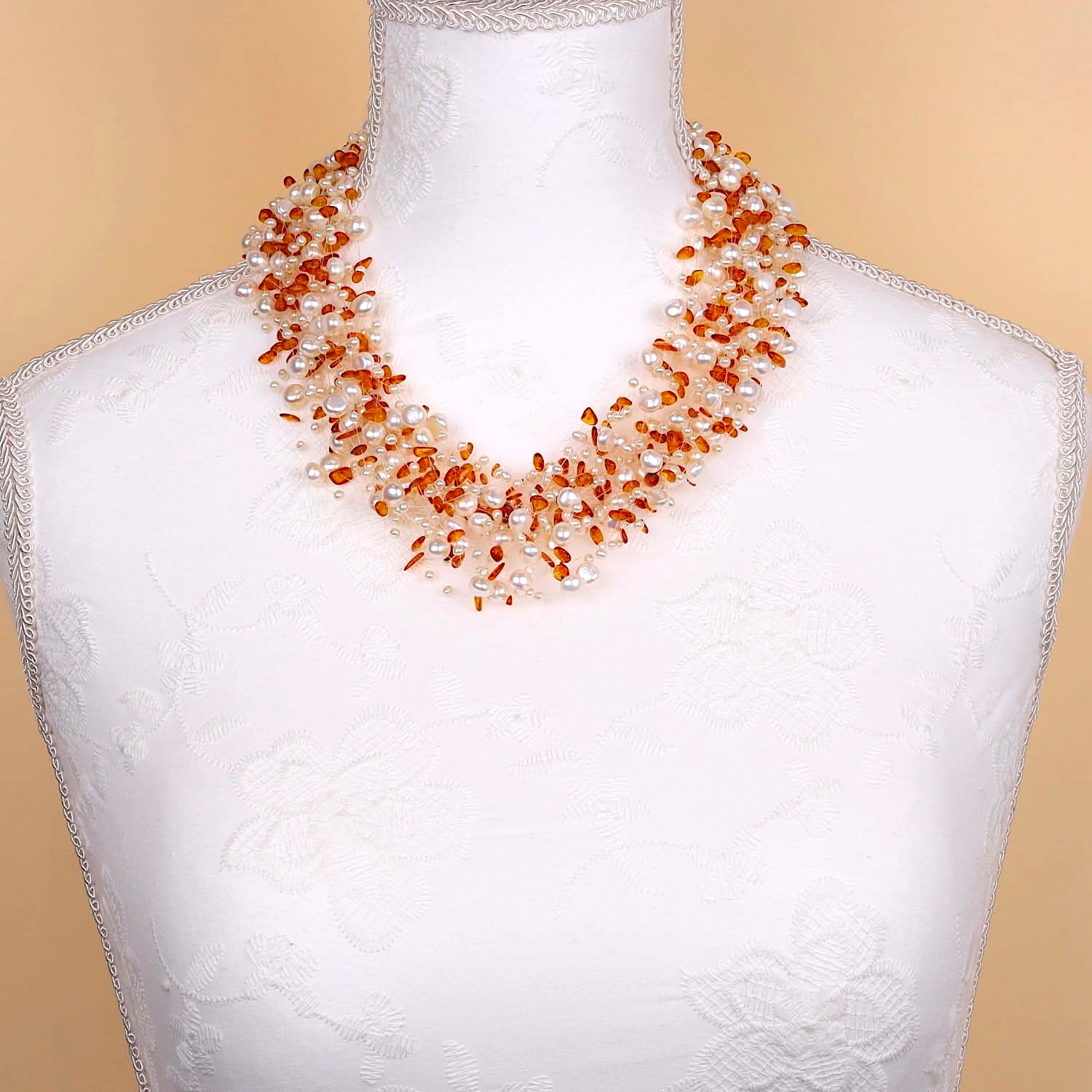 Necklace made of cultured pearls and amber with a lock made of 585 gold, on a white bust