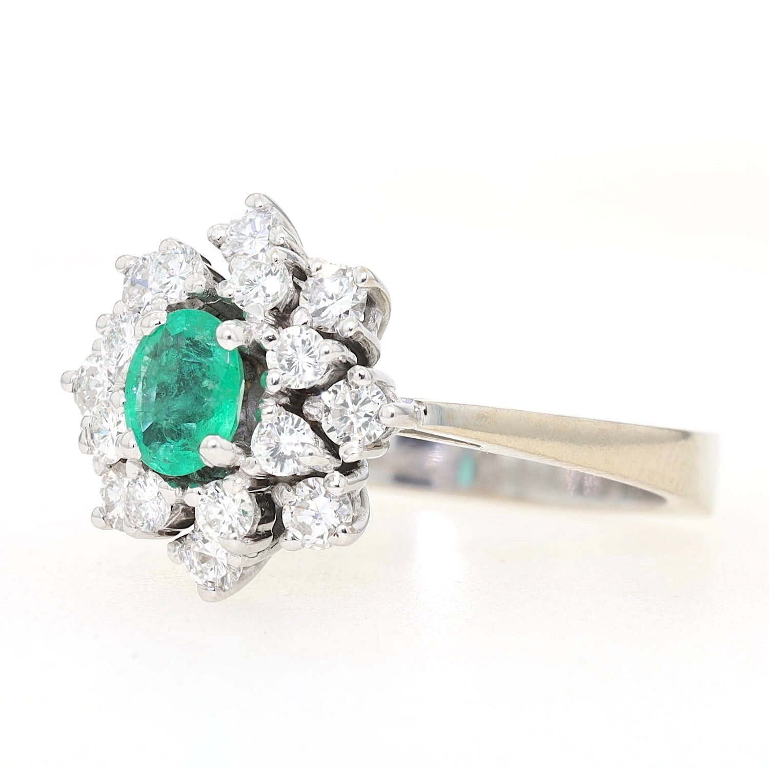 Cocktailring in 585er Weiß- leicht Gelbgold mit einem Smaragd und Brillanten, liegend links gedreht