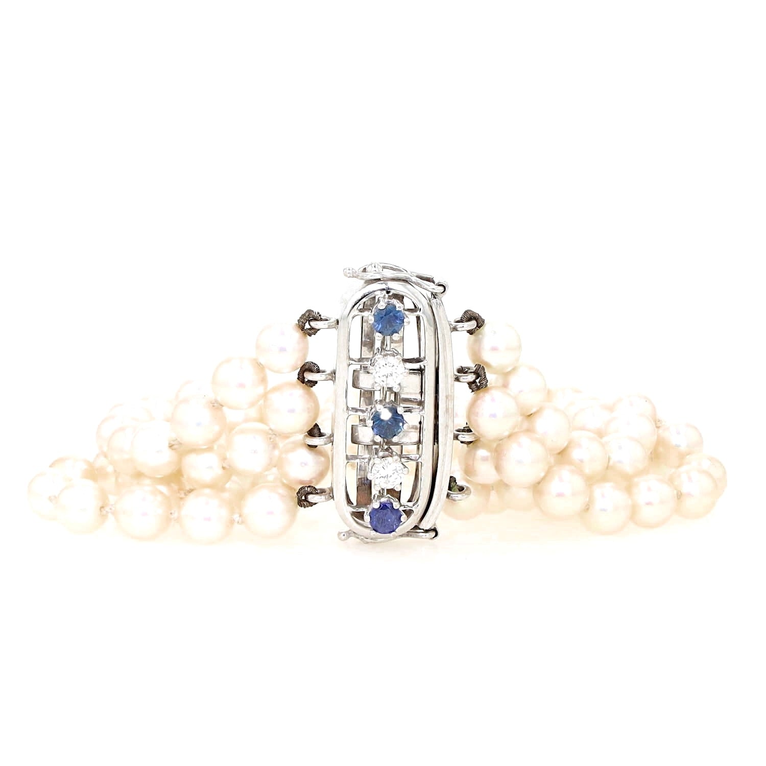Armband aus 4 Reihen Zuchtperlen mit einem Schloß aus 585er Weißgold mit Saphiren und Brillanten, liegend etwas zusammen geschoben mit Sclhoß frontal