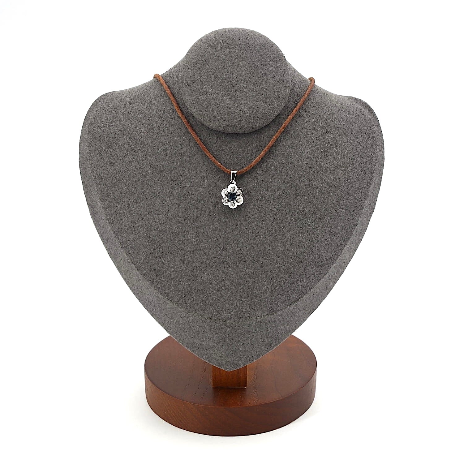 Anhänger in 585er Weißgold mit einem blauen Saphir und Brillanten, an einer dunklen Büste