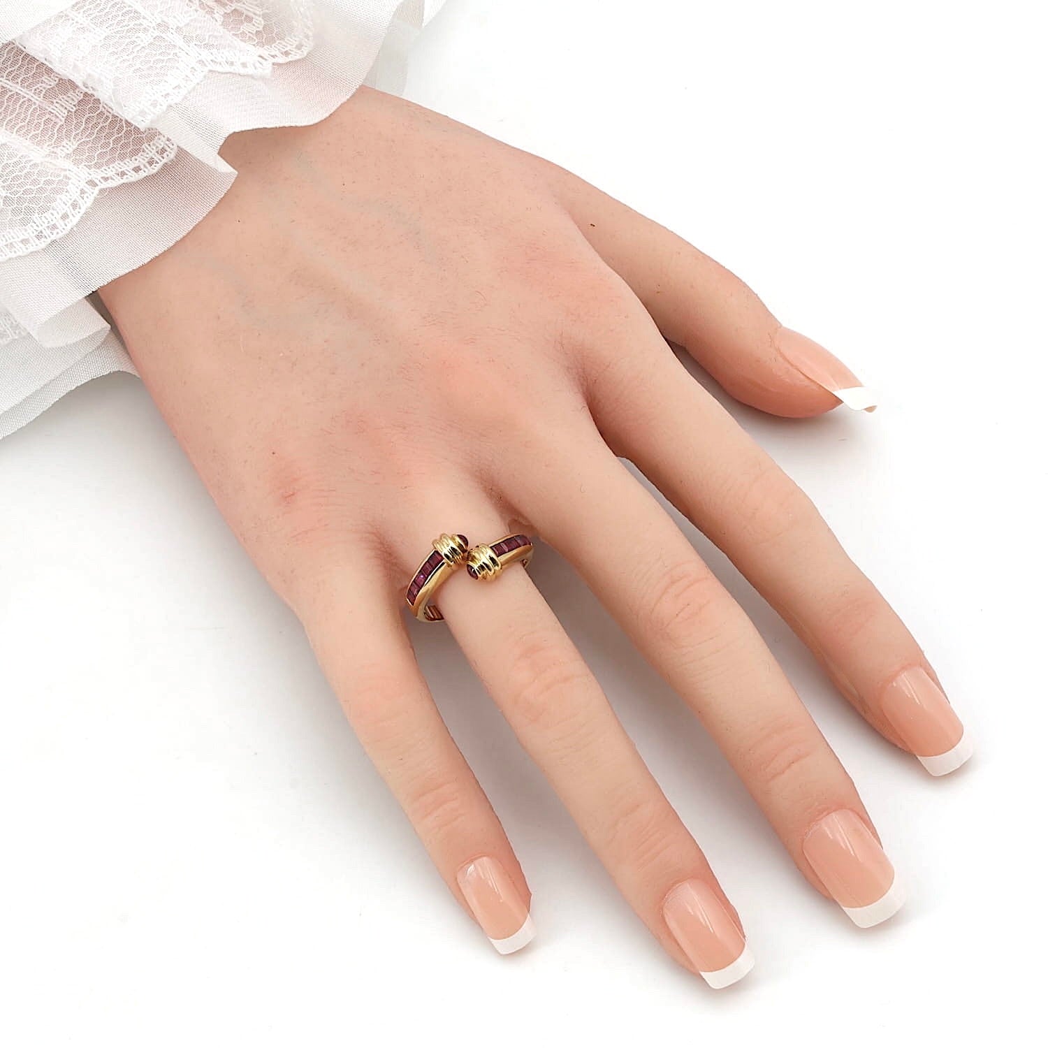 Ring in 750 yellow gold with rubies, on an artificial hand