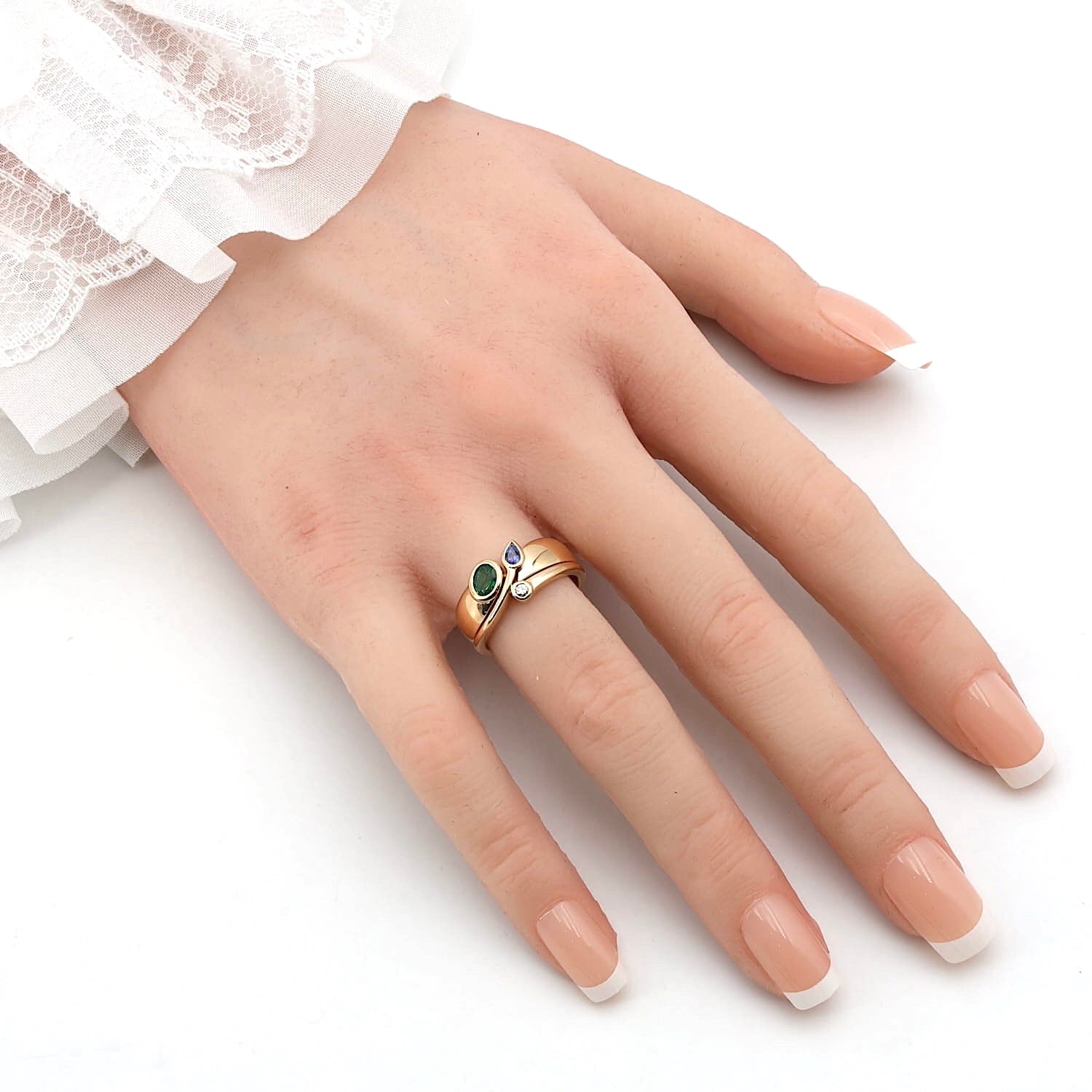 Cadeaux ring in 750 yellow gold with with a brilliant, a blue sapphire and an emerald, on an artificial hand