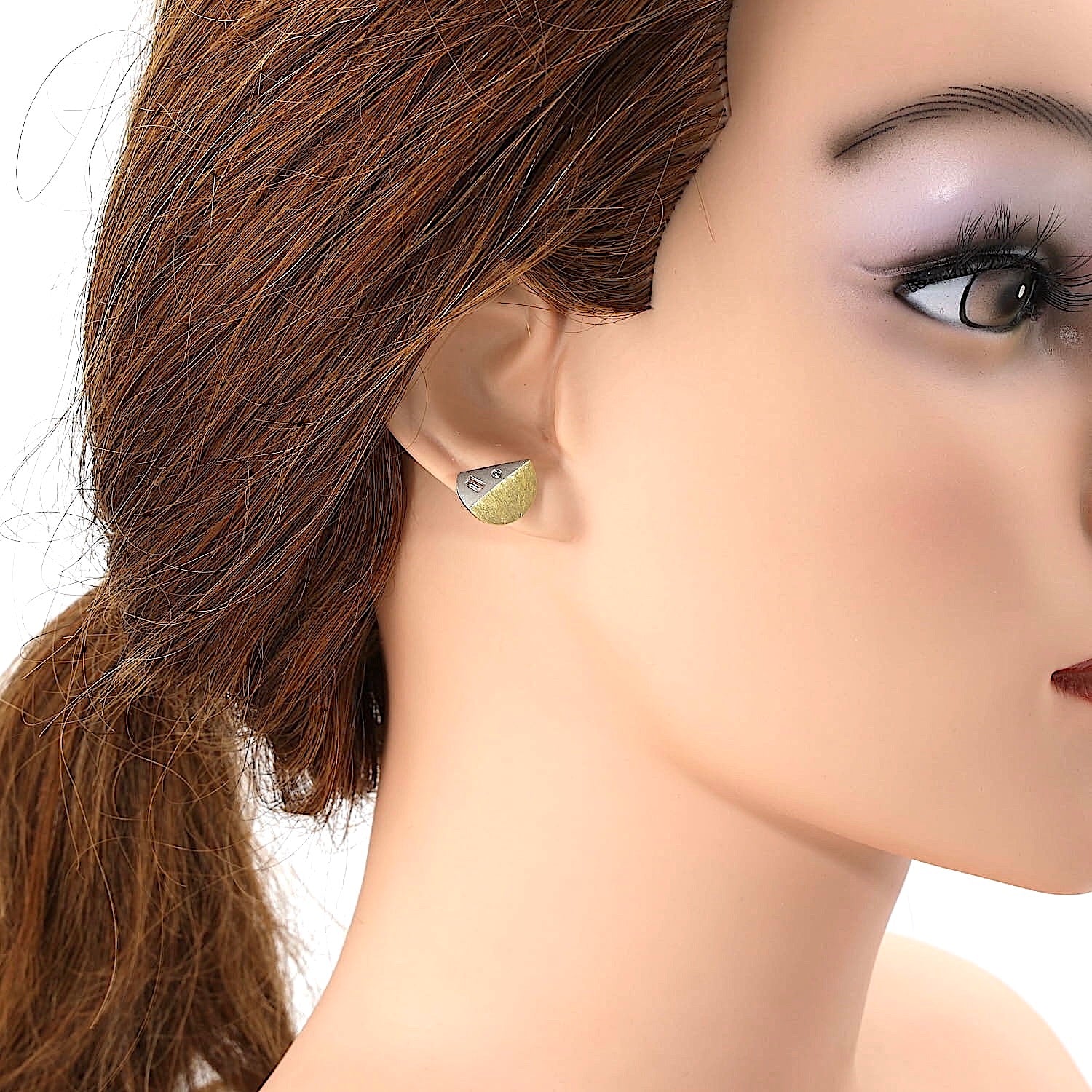 Stud earrings in platinum and 18k yellow gold with diamonds on a doll's ear