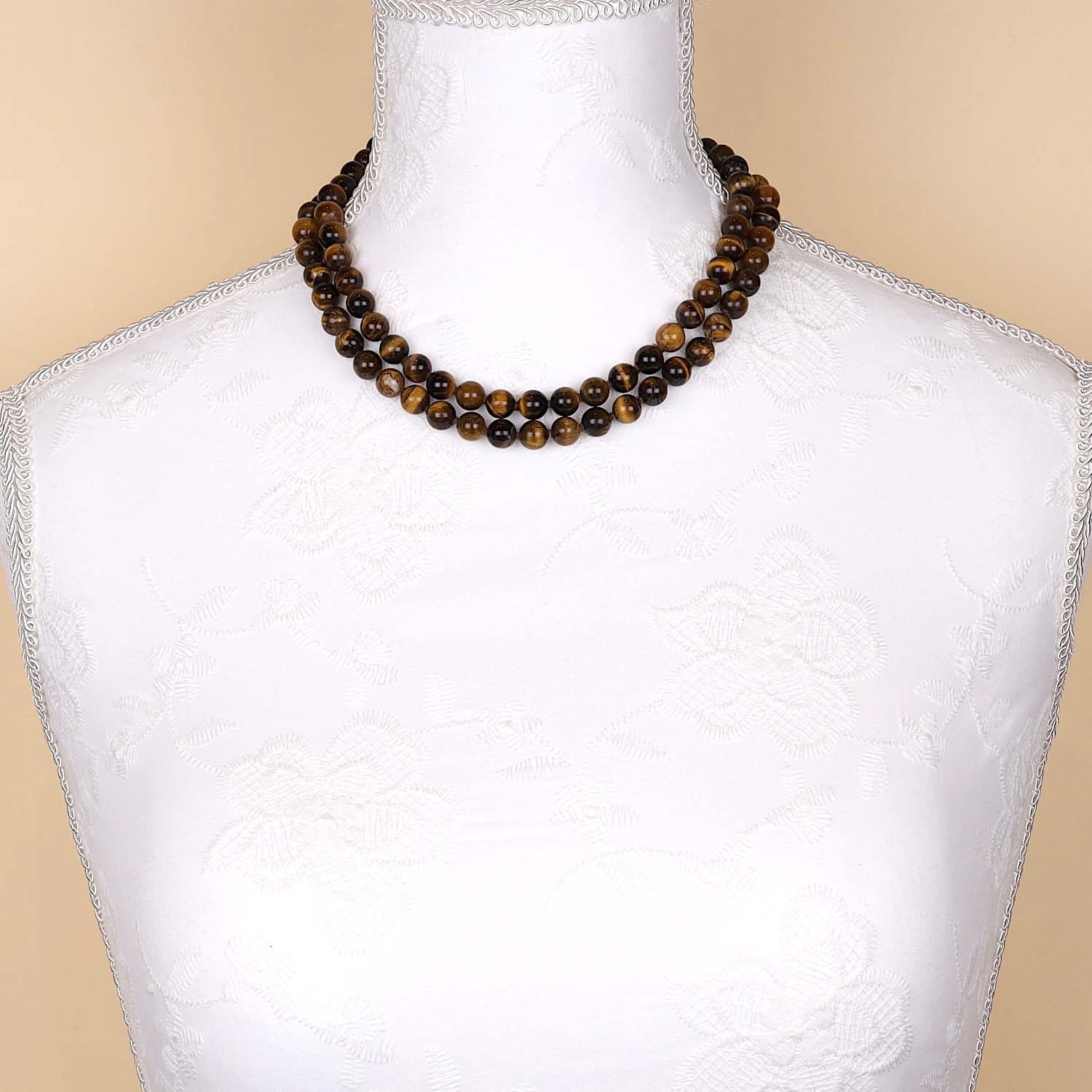 Long endless chain with tiger eye balls on a white bust