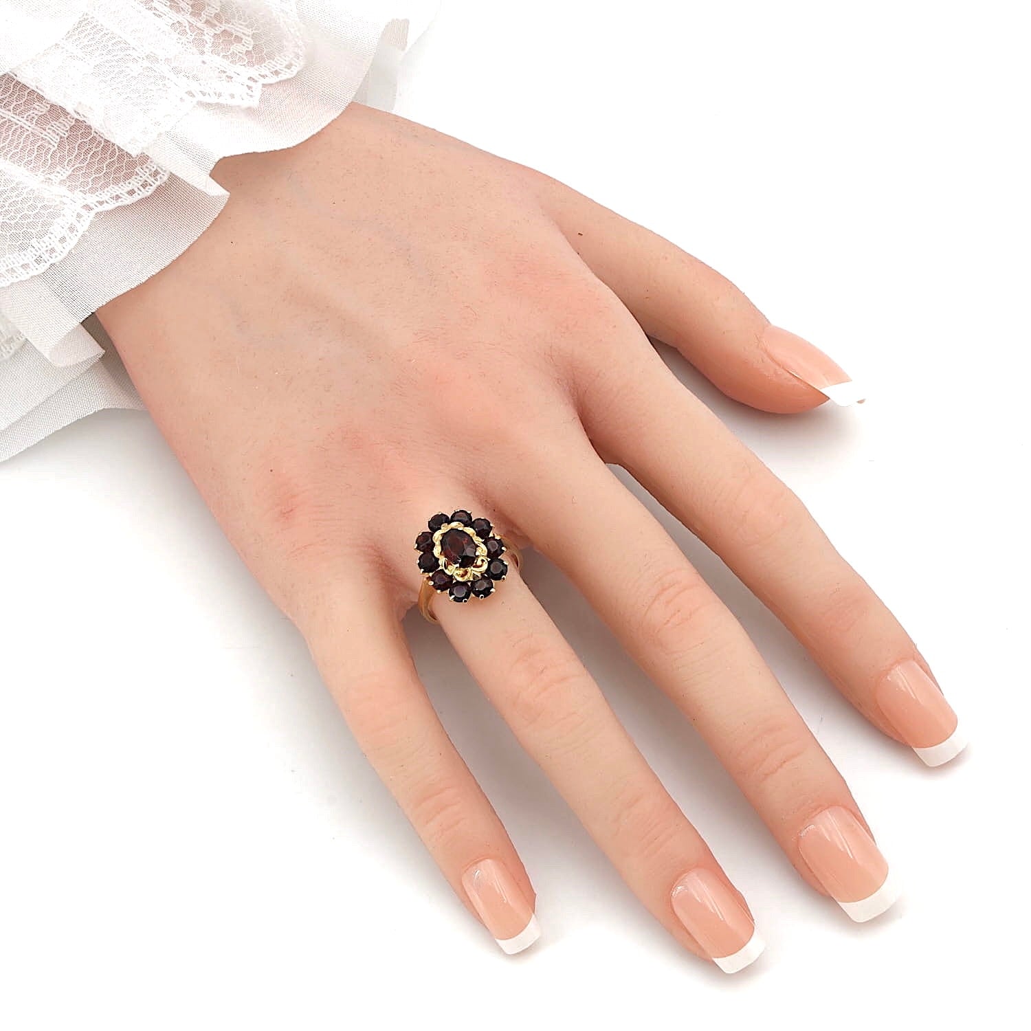 Ring in 750 yellow gold with garnets, on an artificial hand