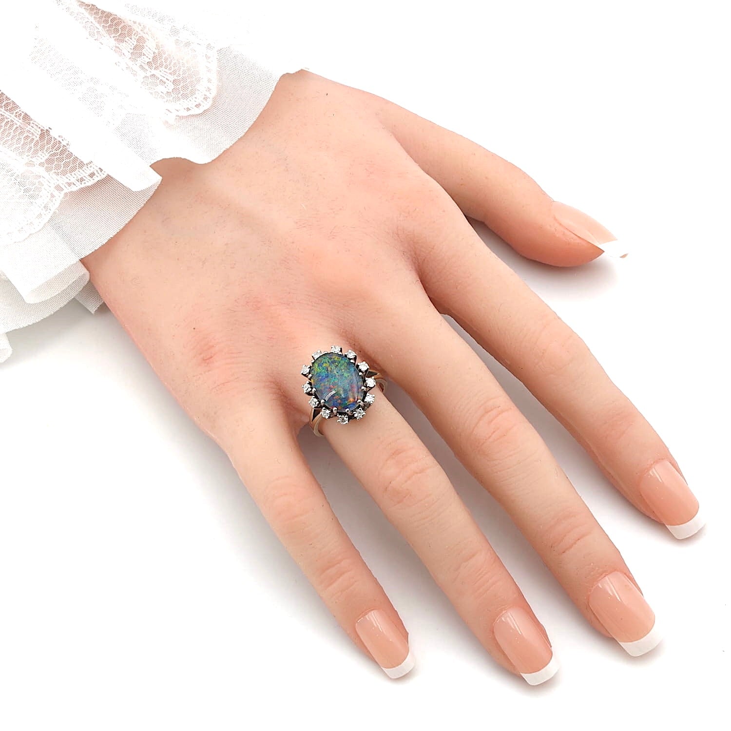 Ring in 585 rhodium-plated white gold with an opal triplet and diamonds, on an artificial hand