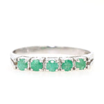 Ring in 585 white gold with emeralds, lying frontally