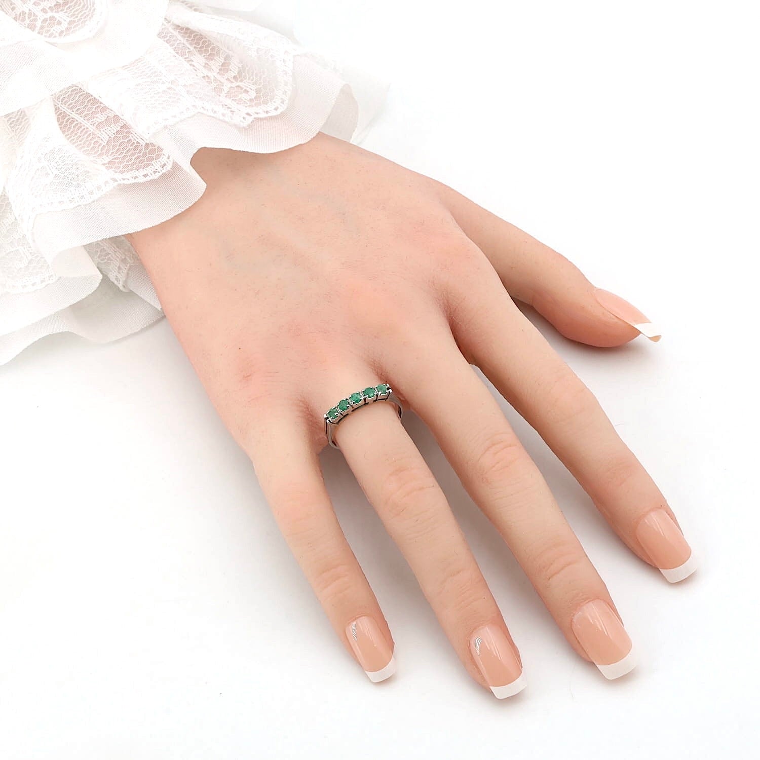 Ring in 585 white gold with emeralds, on an artificial hand