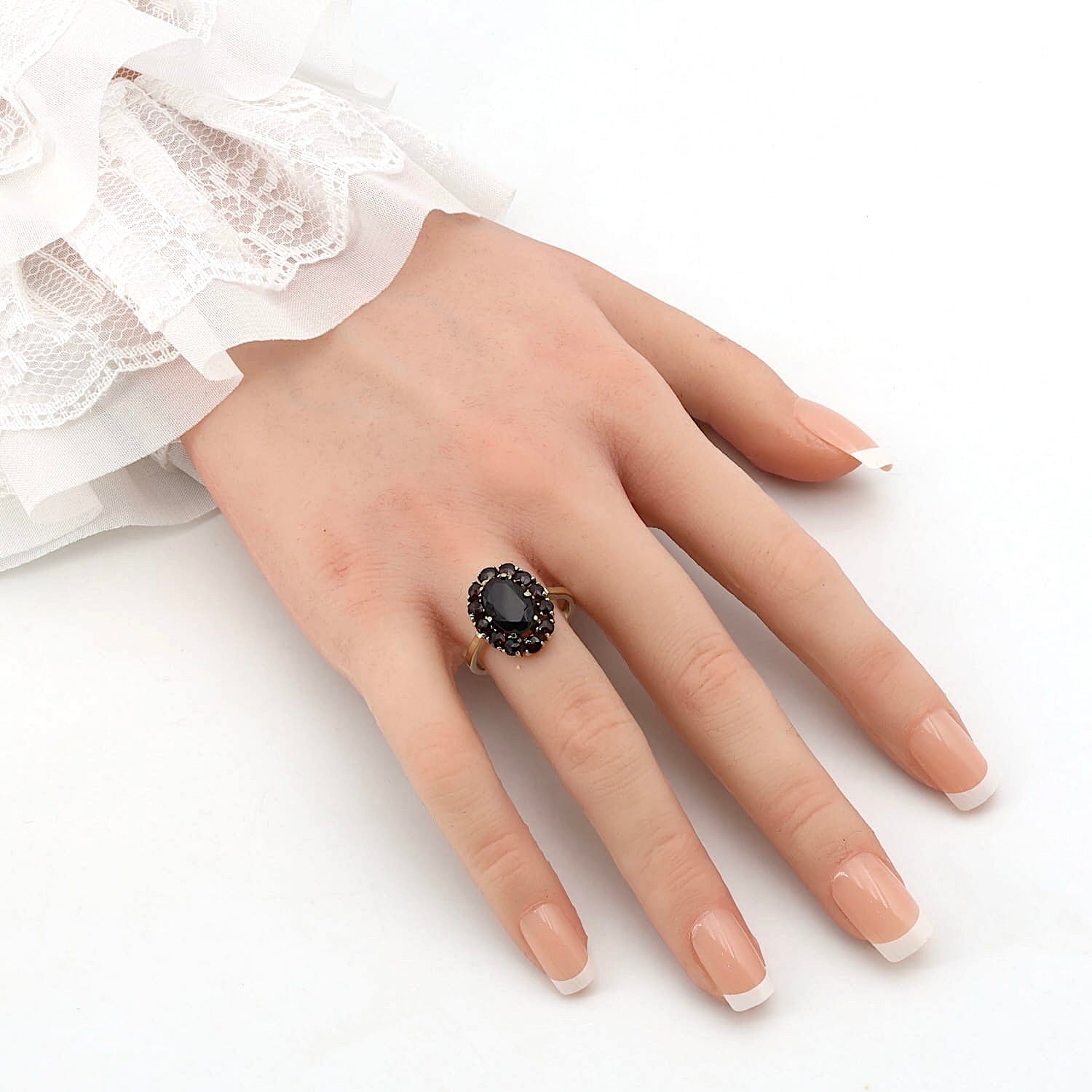 Garnet ring in 333 yellow gold, on an artificial hand