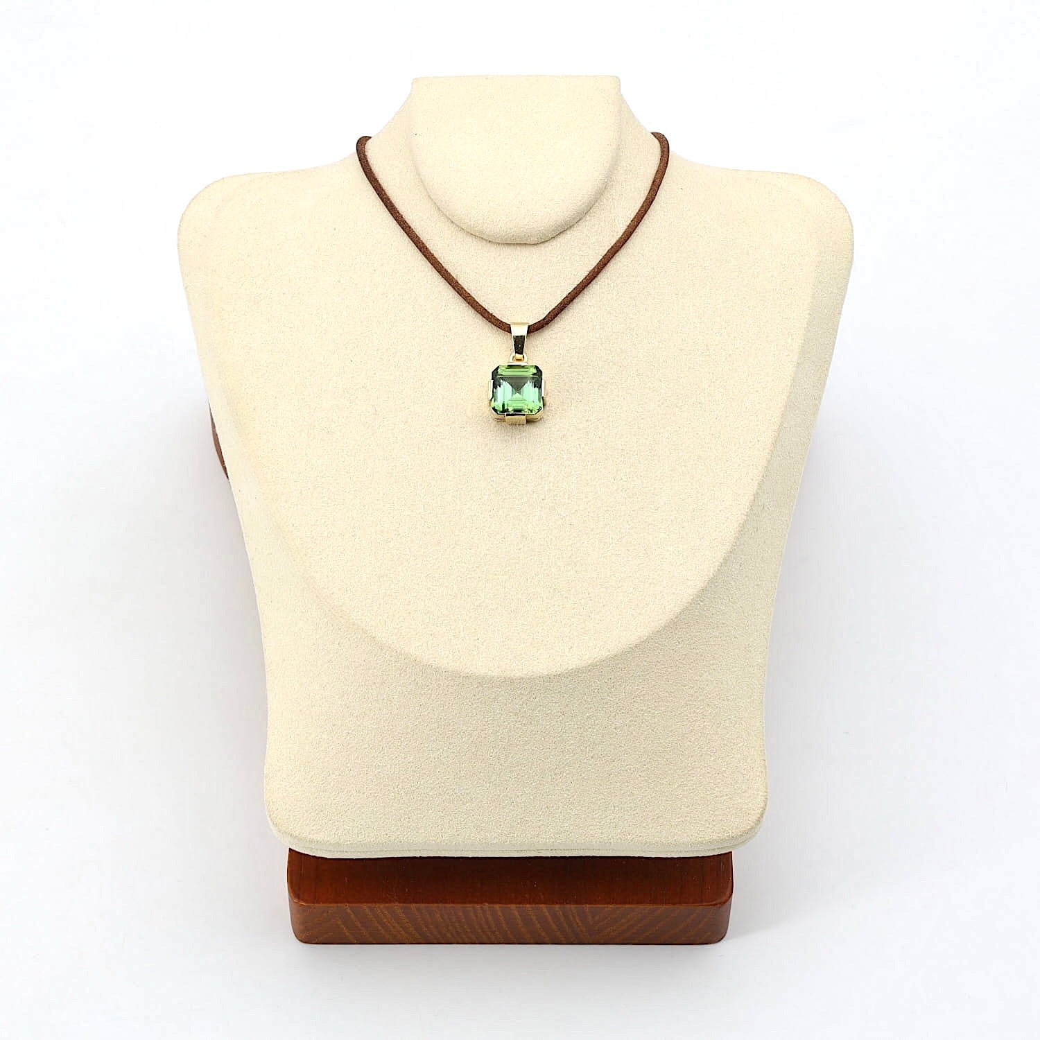 Anhänger in 585er Gelbgold mit einem Turmalin, an einer hellen Büste