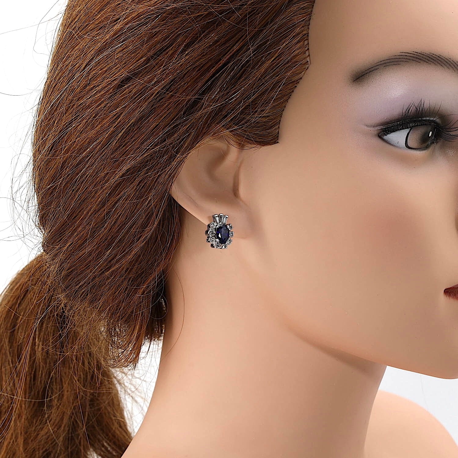 Ohrstecker in 585er Weißgold mit je einem blauen Saphir, Diamanten und Brillanten, am Ohr einer Puppe