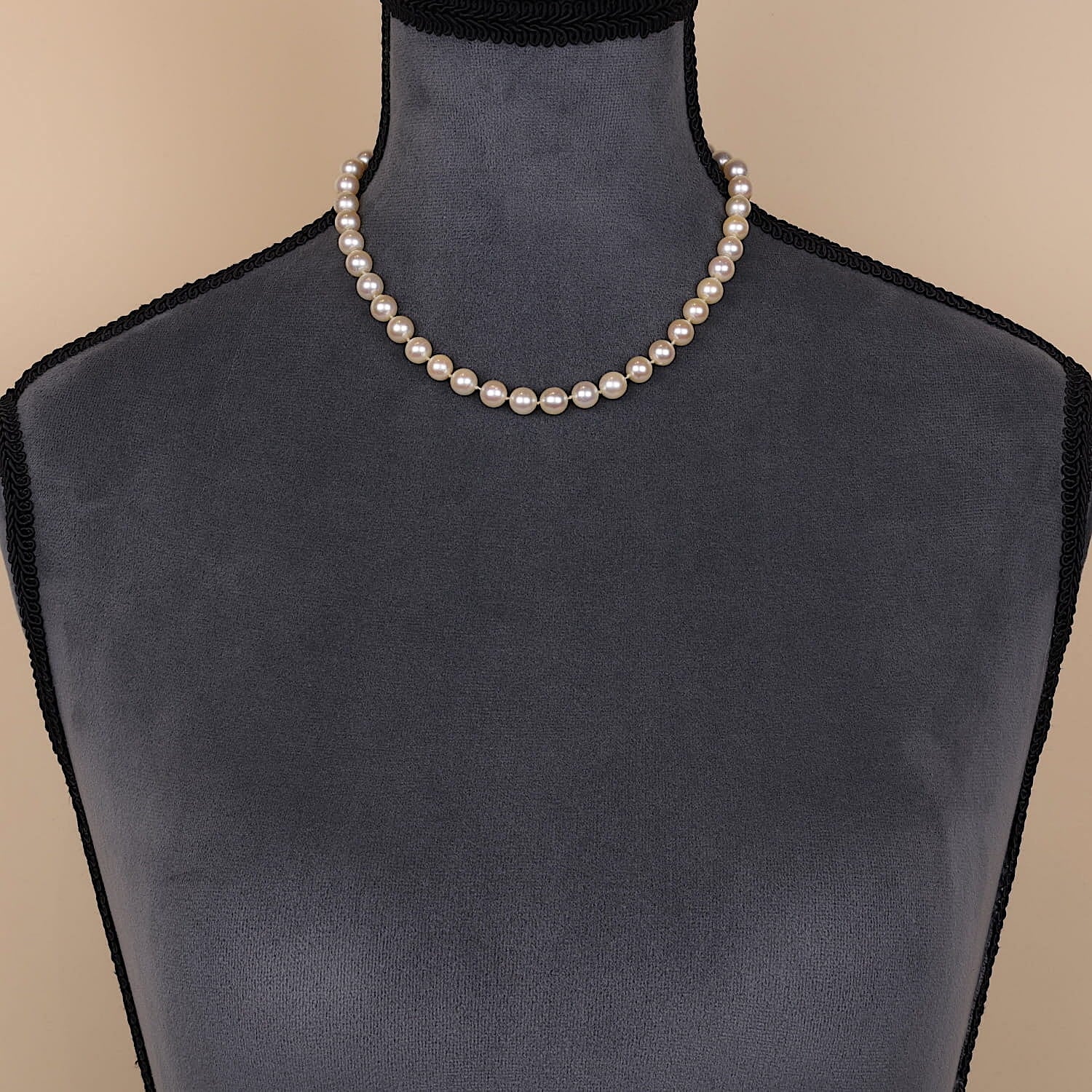 Cultured pearl necklace with a lock made of 585 white gold, on a dark bust