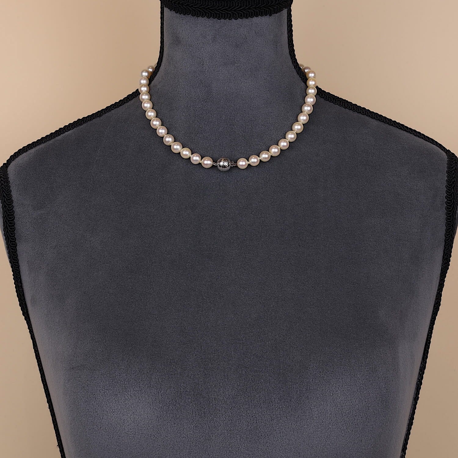 Cultured pearl necklace with a lock made of 585 white gold, on a dark bust lock at the front