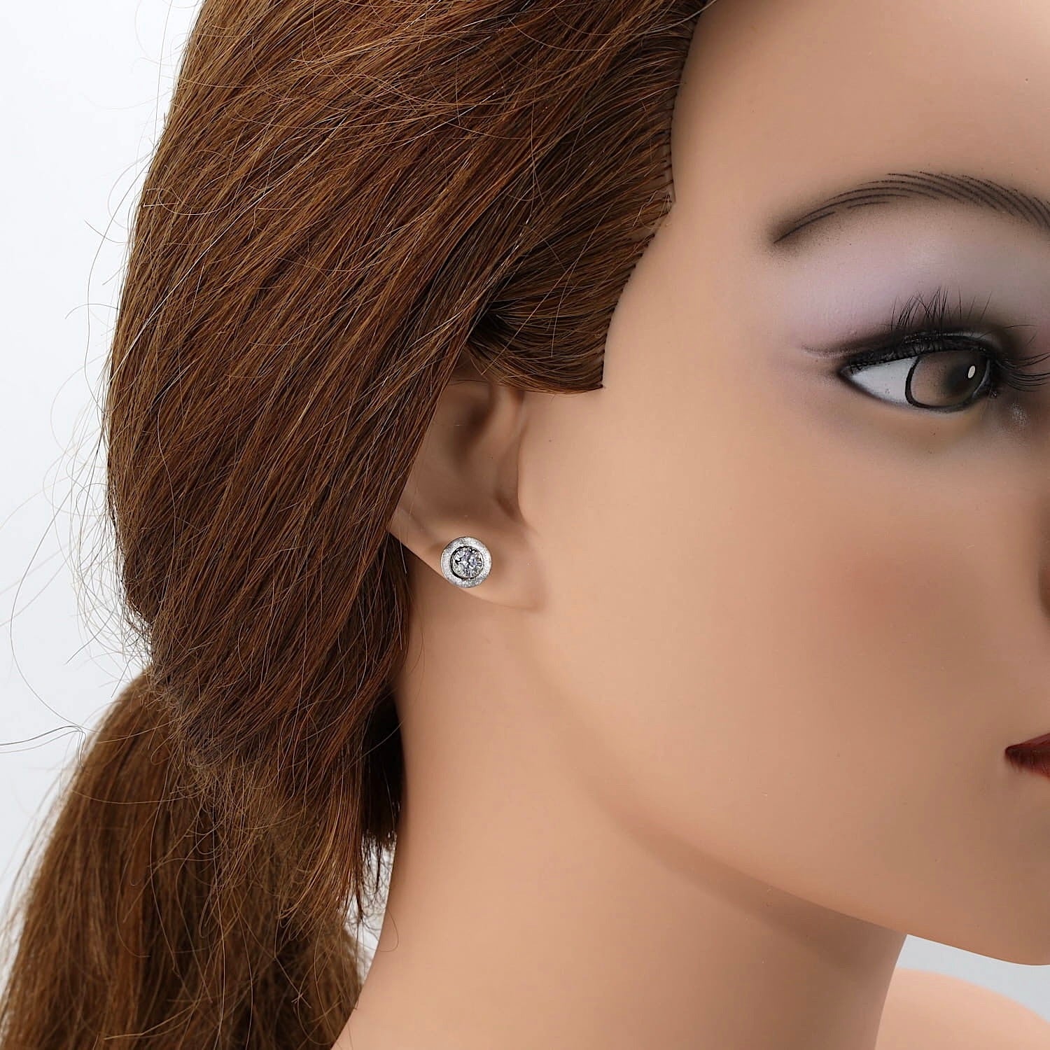 Ohrstecker in 585er Gelb- und Weißgold mit je einem Brillanten, insgesamt ca. 0,60 ct, am Ohr einer Puppe