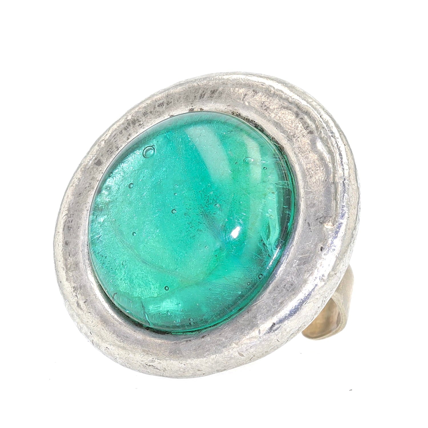 Statement ring made of pewter with a green glass stone, lying slightly to the right