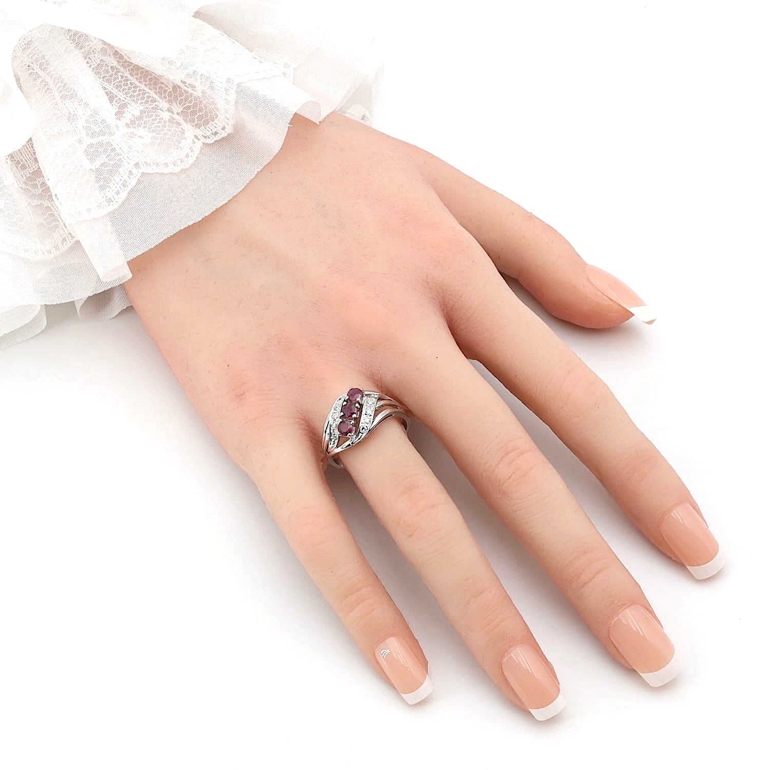 Ring in 585 white gold with rubies and diamonds, on an artificial hand