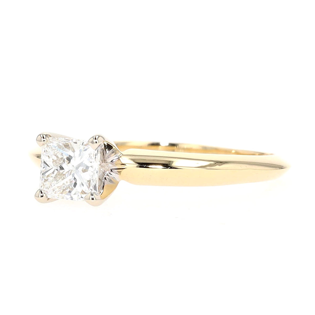 Solitaire ring in 750 yellow gold with a princess-cut diamond, lying frontally slightly turned to the left