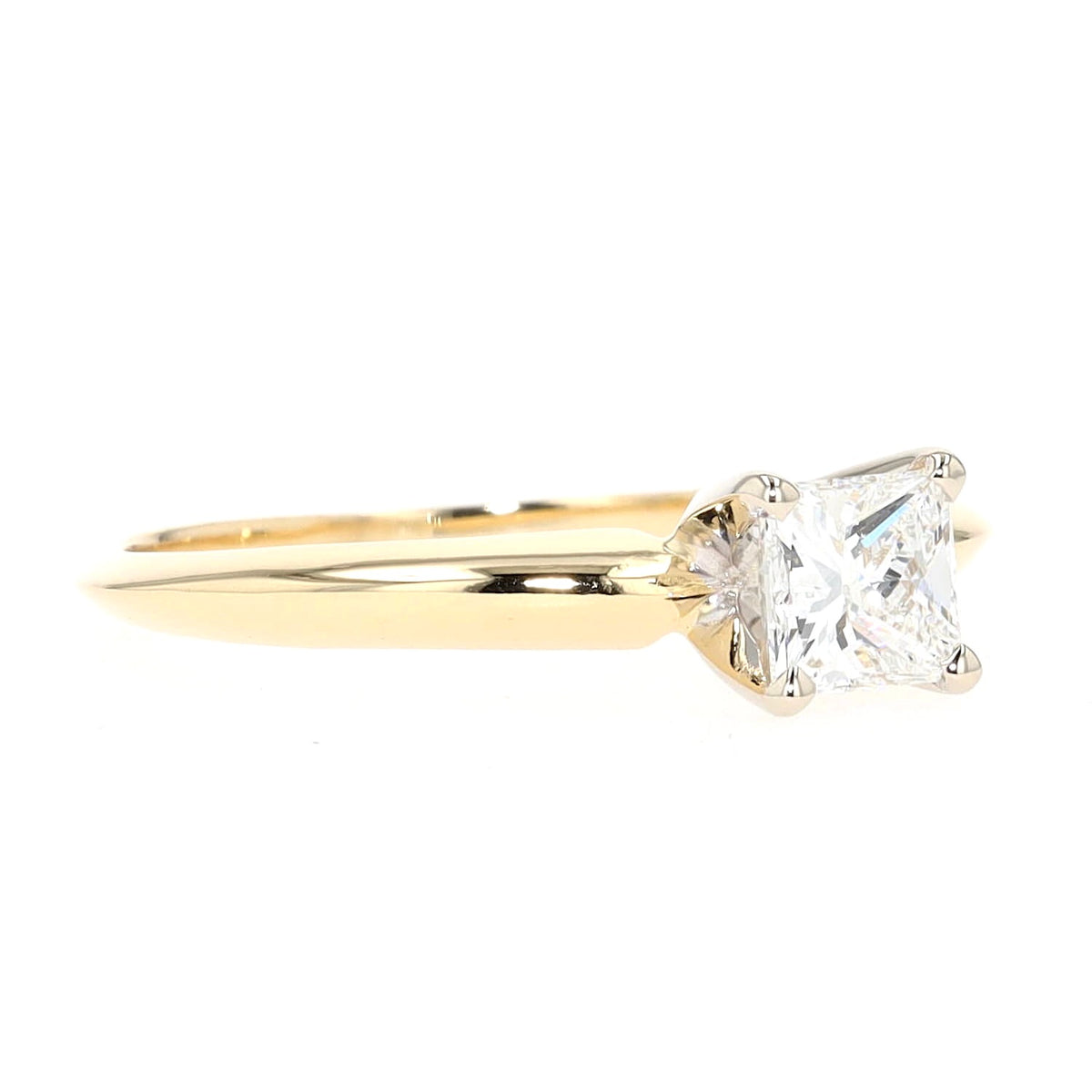 Solitaire ring in 750 yellow gold with a princess-cut diamond, lying frontally slightly to the right rotated