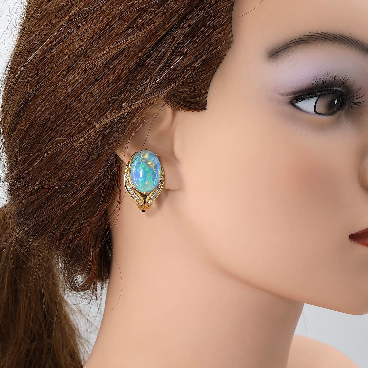 Ohrclips in 750er Gelb- und Weißgold mit je einer Opal-Triplette, Brillanten und Diamanten, am Ohr einer Puppe