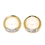 Clip-on earrings in 585 yellow gold, each with a large size.cultured pearl and diamonds, lying frontally