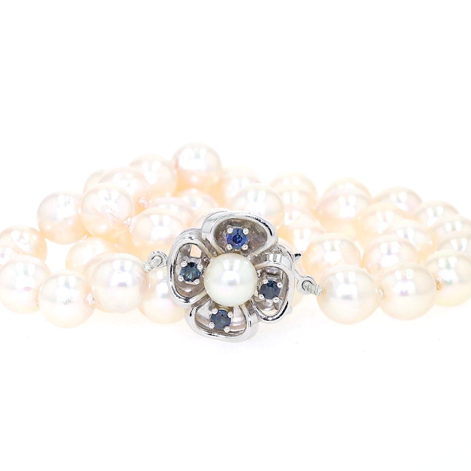 Cultured pearl necklace with a lock made of 585 white gold with a cultured pearl and blue sapphires, lying folded lock in front
