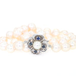 Cultured pearl necklace with a lock made of 585 white gold with a cultured pearl and blue sapphires, lying folded lock in front