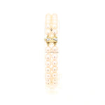 Akoya-Zuchtperlenarmband in zwei Reihen mit einem Schloss und Goldelementen aus 585er Gelbgold mit Diamanten, stehend auf einem Halter aus Kunststoff 