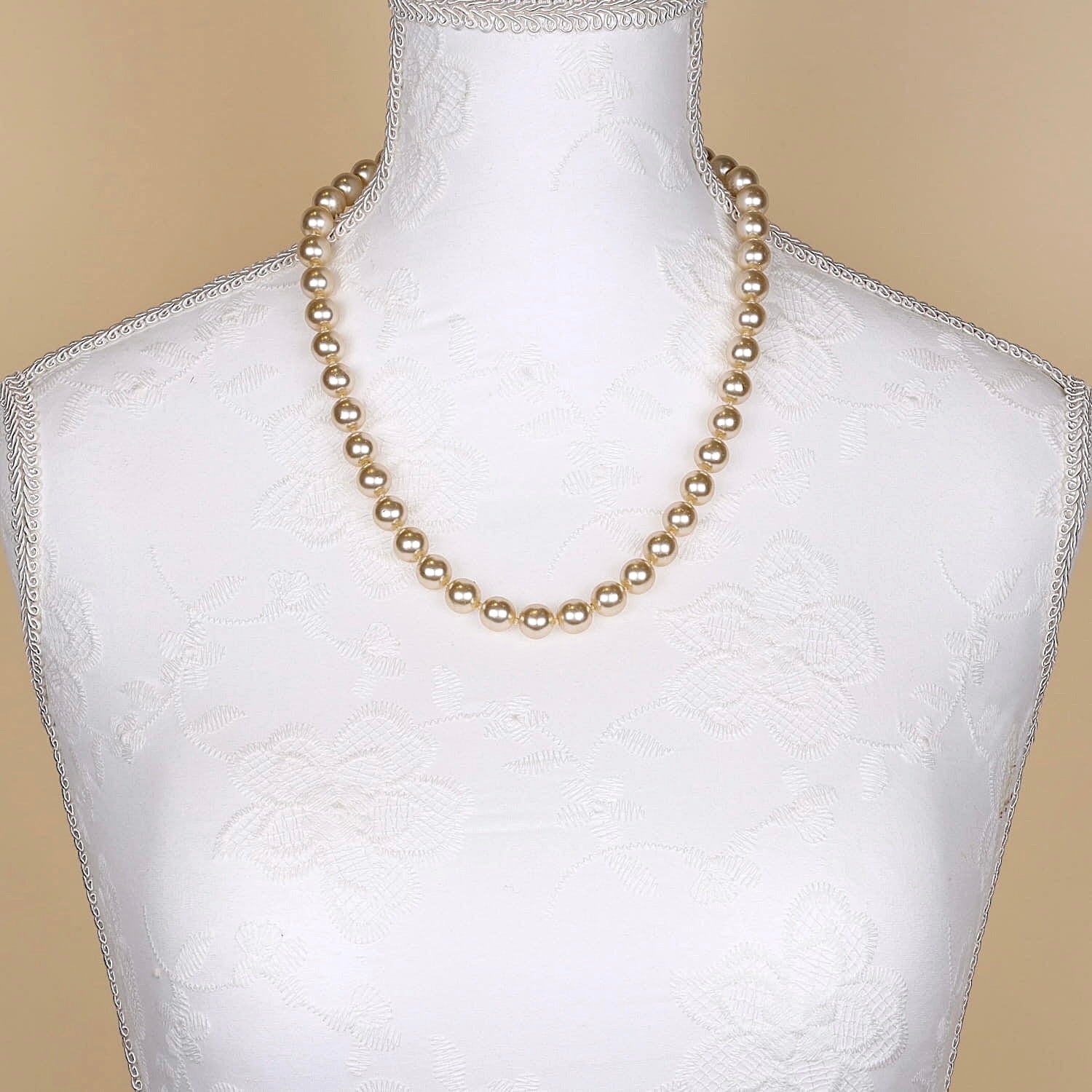Shell bead necklace with gold-colored beads and a magnetic lock made of 585 yellow and white gold, on a light bust