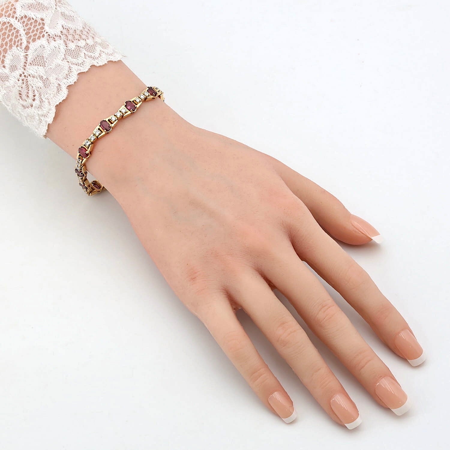 Armband in 585er Gelbgold mit Brillanten und Rubinen, an einem künstlichen Arm